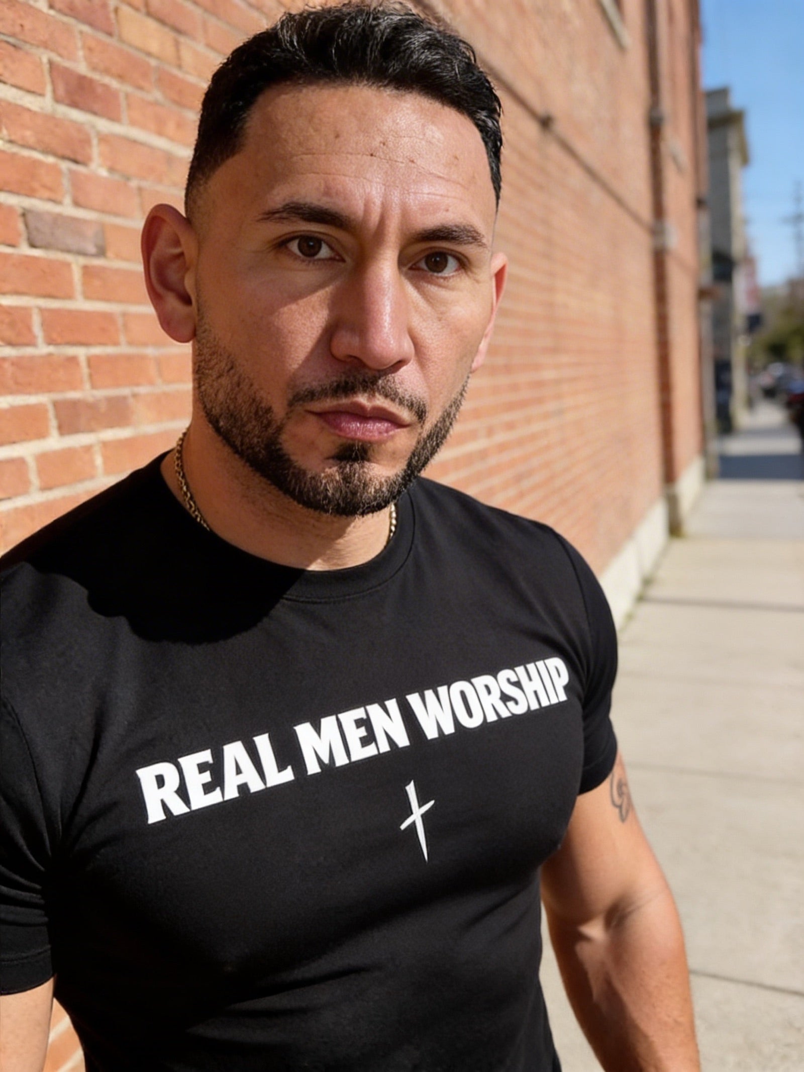 Close portrait of a man wearing a black Real Men Worship faith-based T-shirt